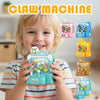 A young child holds a green claw machine toy, demonstrating the portable arcade game for kids.