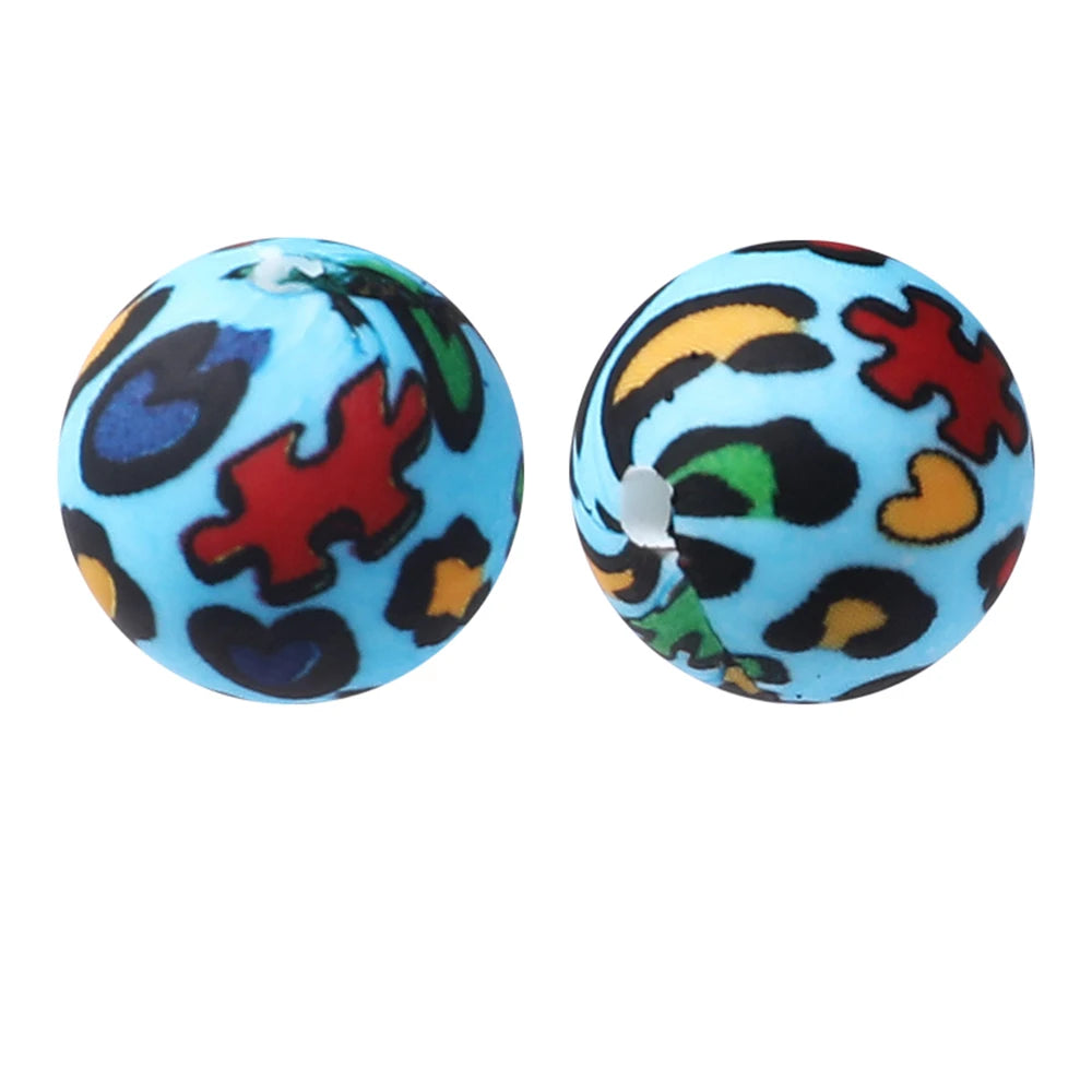 A pair of round silicone beads with a leopard print design in blue and black.