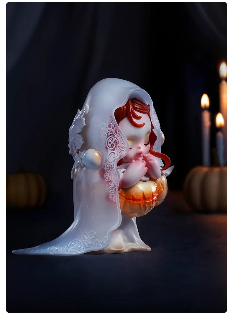 A translucent white plush doll pendant with a sheer veil and red hair resting on an orange pumpkin.