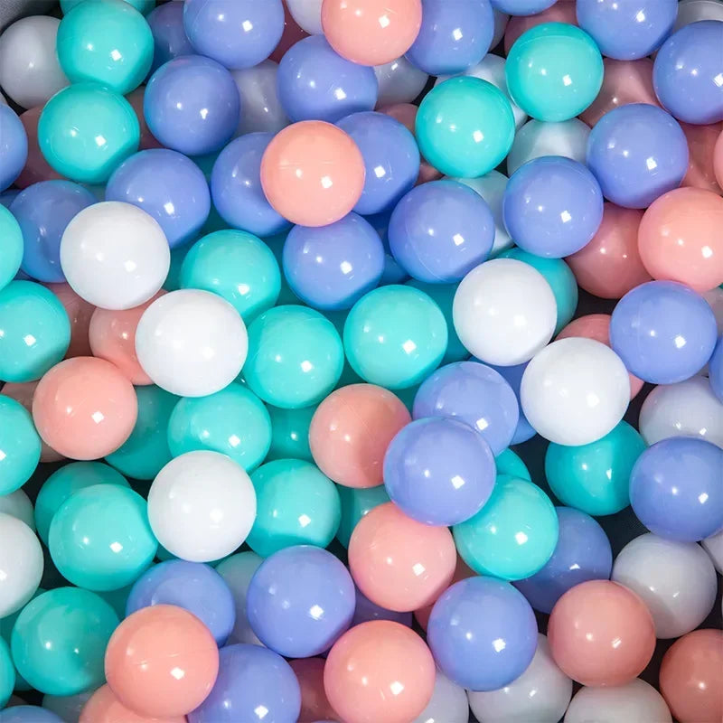 A bulk set of colorful plastic ocean ball pit toys in various shades of blue, pink, and white.