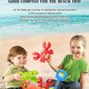 A young girl is playing with a set of red crab claws and green dinosaur digging tools on the sand.