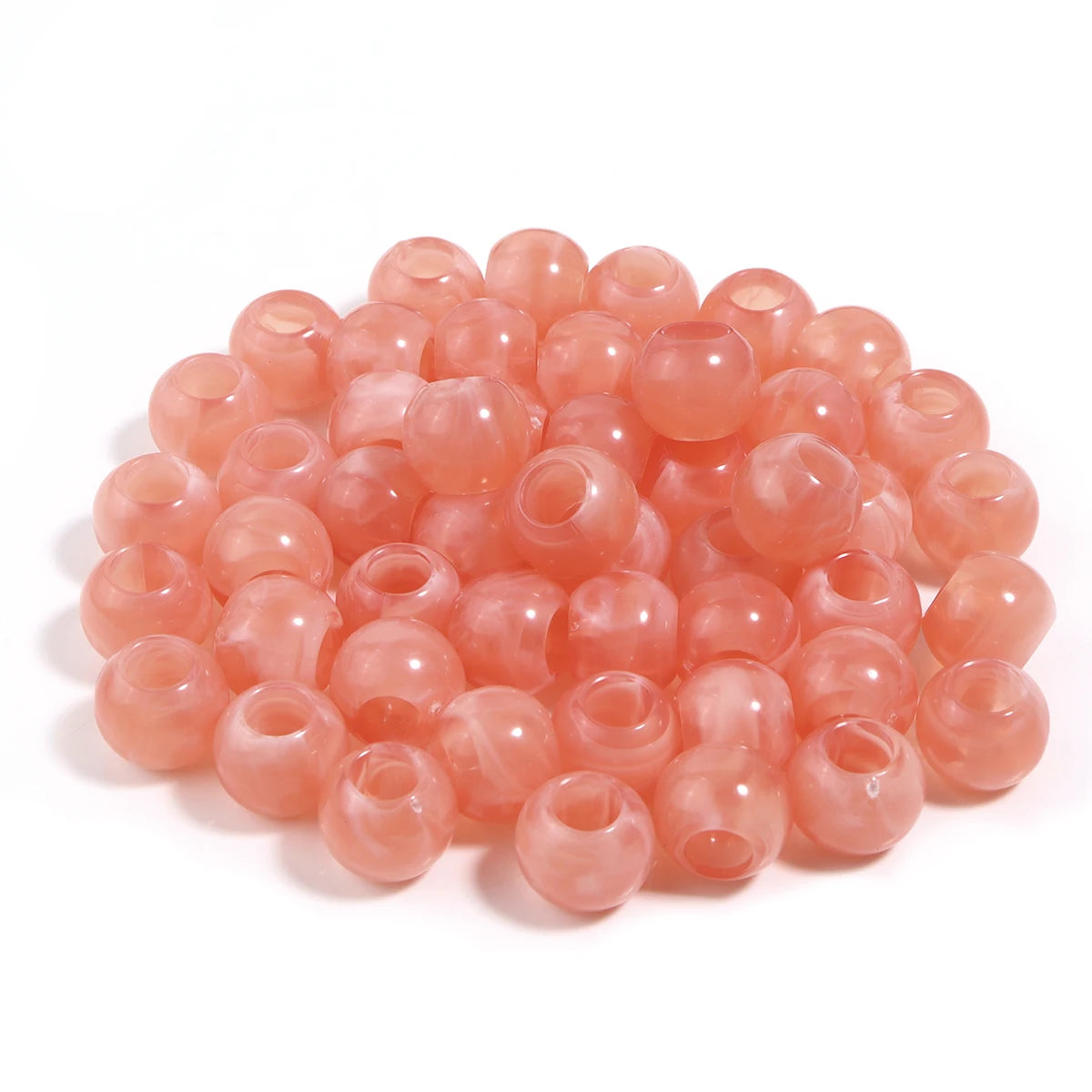 A pile of 50 imitation jade acrylic cloud beads in a translucent pink color for jewelry making.