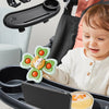 A child is using a black stroller tray with an attached snack tray and phone holder.