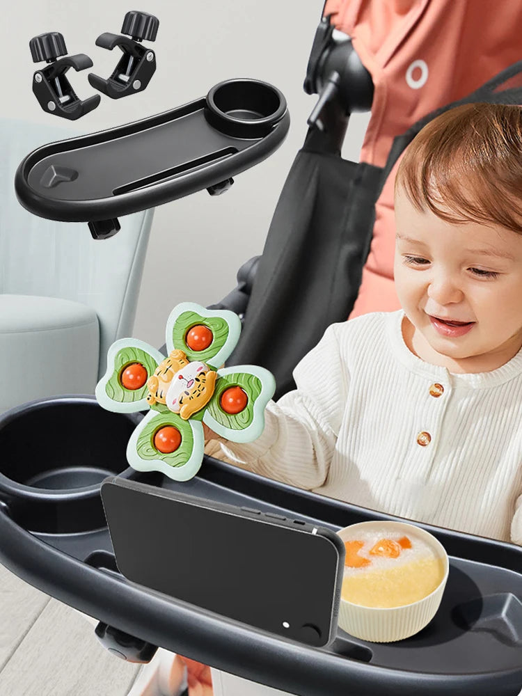 A child is using a black stroller tray with an attached snack tray and phone holder.