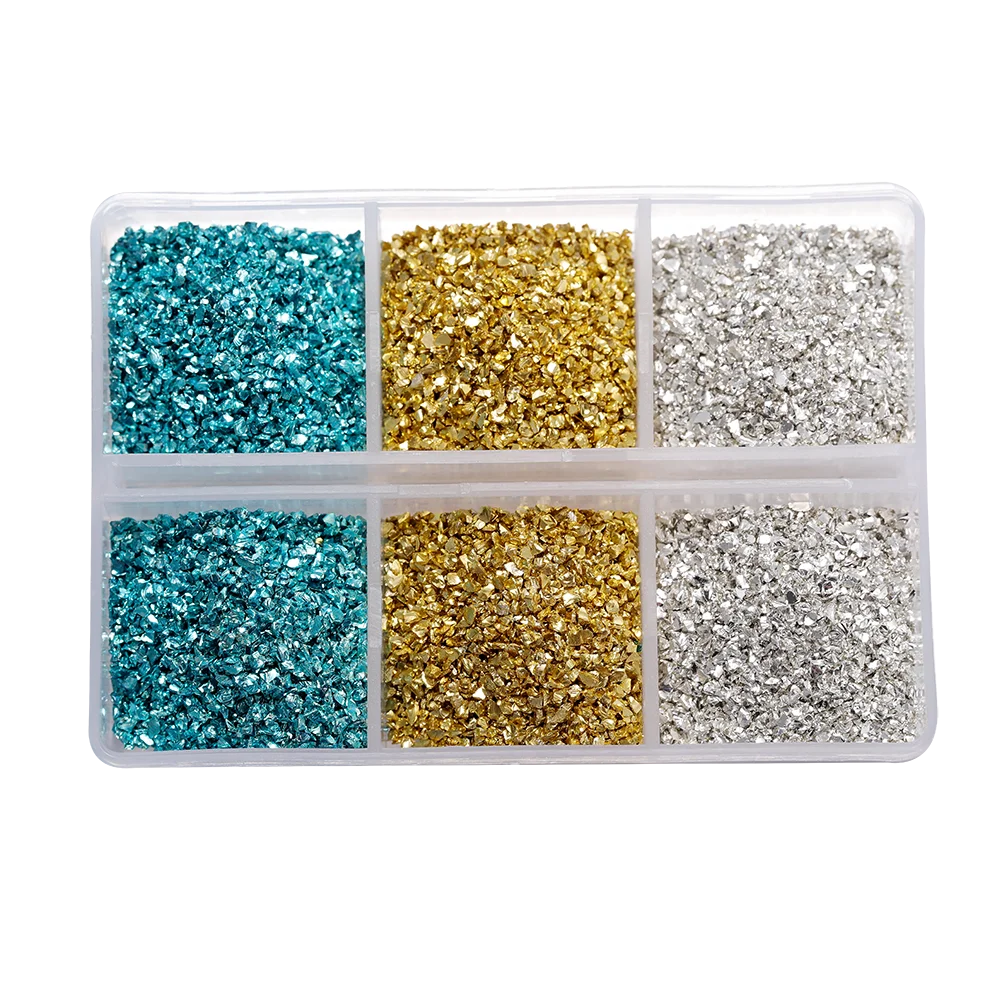 A clear plastic container holding four compartments filled with colored crushed glass stones: blue, gold, silver, and blue ag