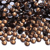 A close-up view of dark brown and amber glass crystal hot fix rhinestones scattered on a white background.