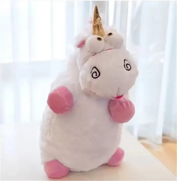 A white unicorn plush toy with a golden horn and pink accents sitting on a white surface.
