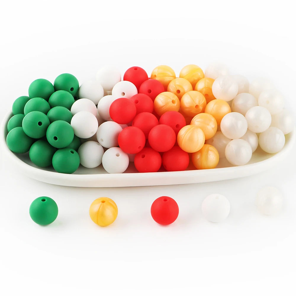 A collection of round silicone beads in various colors including green, white, yellow, and red arranged in a line.