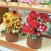A bouquet of red roses and yellow sunflowers made from building blocks displayed in a glass case.