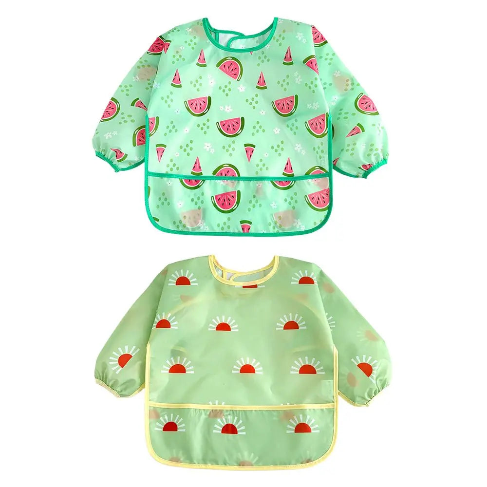 A pair of light green waterproof baby bibs with a watermelon pattern.