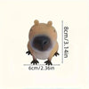 A light brown squishy toy shaped like a capybara with a dark nose and small paws.