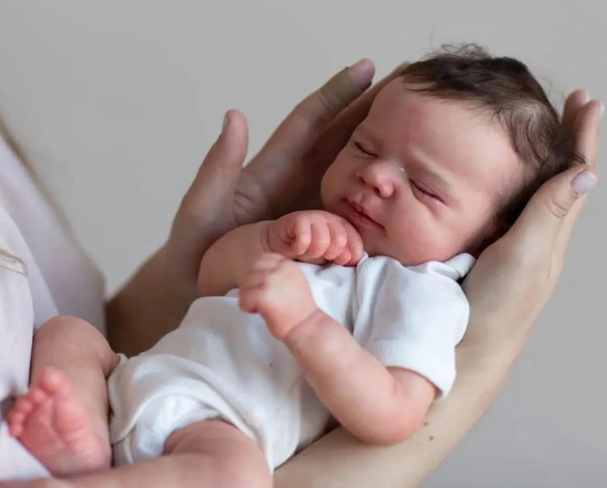 A newborn baby with hand-rooted hair is being held by a person.