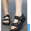 A pair of black boys' non-slip summer sport sandals worn on a person's foot.