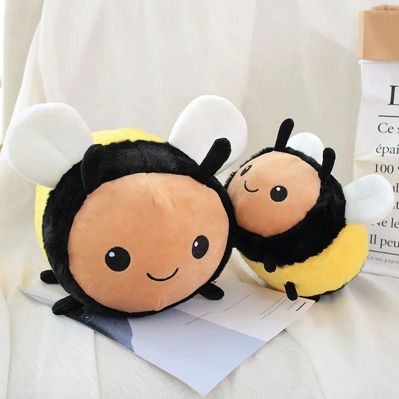 A cute plush toy of a bee with yellow and black stripes resting on white fabric.