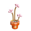 A set of pink and tan building blocks shaped like a tree with round fruit clusters.