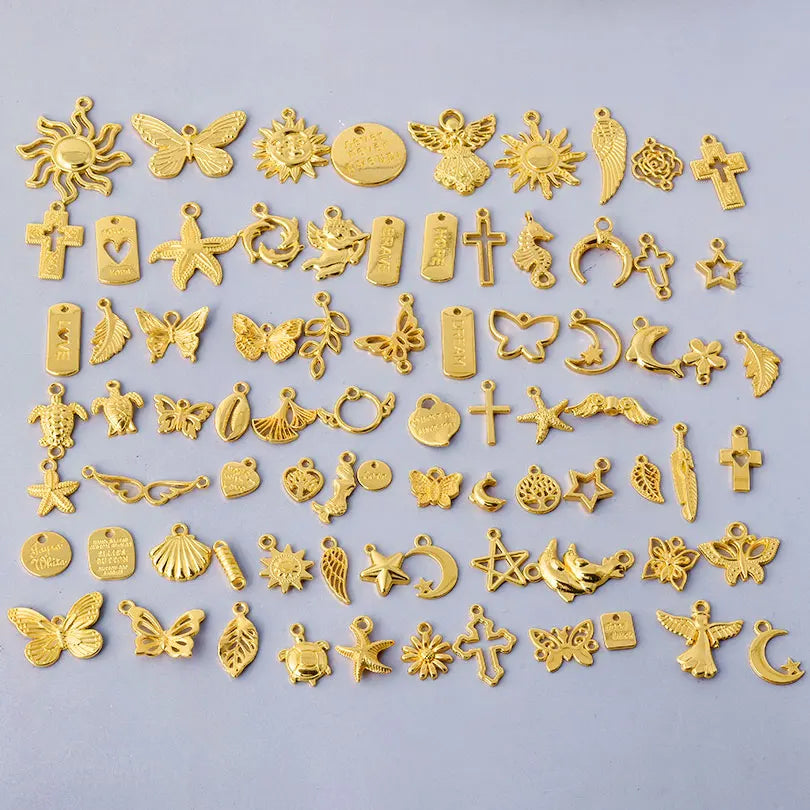 A collection of gold-colored mixed metal charms and pendants for DIY jewelry making.