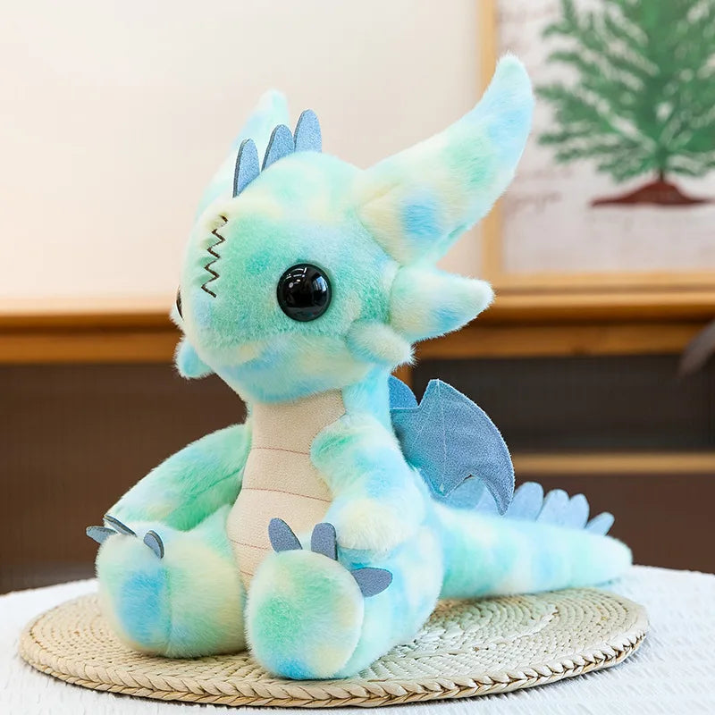 A soft teal and light blue Toothless Dragon plush toy sitting on a woven mat.