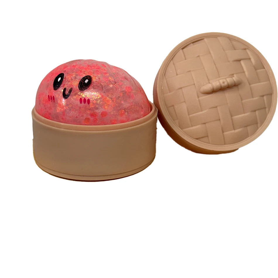Rosa glitzernder Squishy-Dumpling-Sensorspielzeug mit Deckel in beige Behälter.