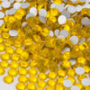 A close-up view of yellow glass crystal flatback rhinestones mixed with white rhinestones.