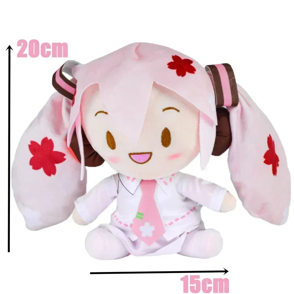A pink Hatsune Miku plush doll with large ears and a smiling face, featuring red flower accents.