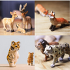 A collection of basswood carvings depicting various wildlife, including deer, foxes, and tigers.