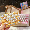 A set of 26 cartoon animal keycap keychains is displayed in a light beige bag.