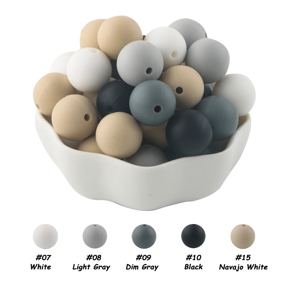 A bowl filled with 50 assorted silicone beads in various shades of gray and white, including black and beige tones.