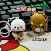 A white and brown cartoon bear couple keychain set displayed on a keyboard background.