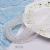 A strand of clear faceted crystal rondelle beads for jewelry making laid on a white surface.