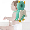 A baby is wearing a green elephant head protector backpack with yellow ears and light green wings.