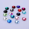 A collection of colorful, round glass crystal flatback rhinestones in various shades including red, blue, green, and pink.
