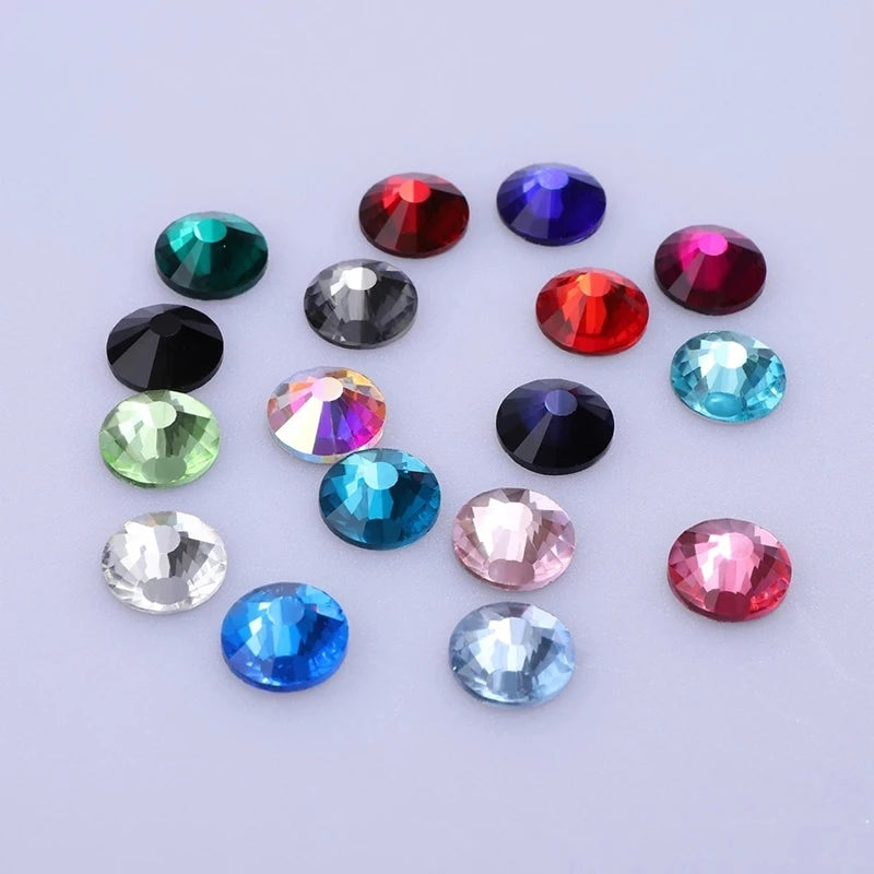 A collection of colorful, round glass crystal flatback rhinestones in various shades including red, blue, green, and pink.