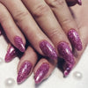 Close-up of fingers displaying a hand painted with holographic glitter nail polish.