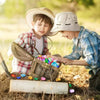 Two boys in hats digging for colorful acrylic gemstones in the dirt.