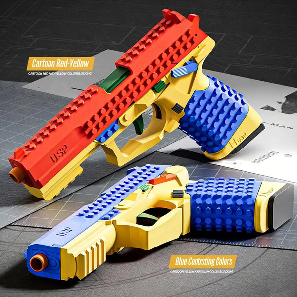 A yellow and red building block toy gun is shown in a side view against a gray background.