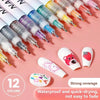 A collection of twelve colored precision nail art pens with fine tips displayed on a pink background.