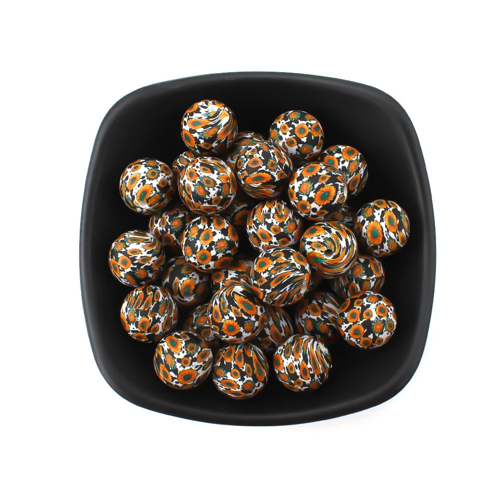 A pile of small, round silicone beads featuring an orange and black leopard print design in a black dish.