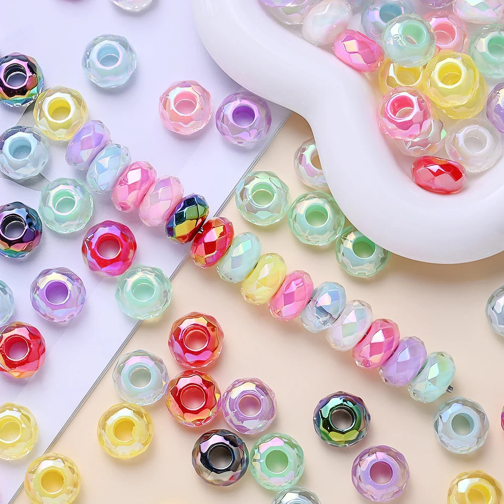 Collection de perles de séparation en acrylique facettées colorées, de différentes nuances et tailles, arrangées sur un fond 
