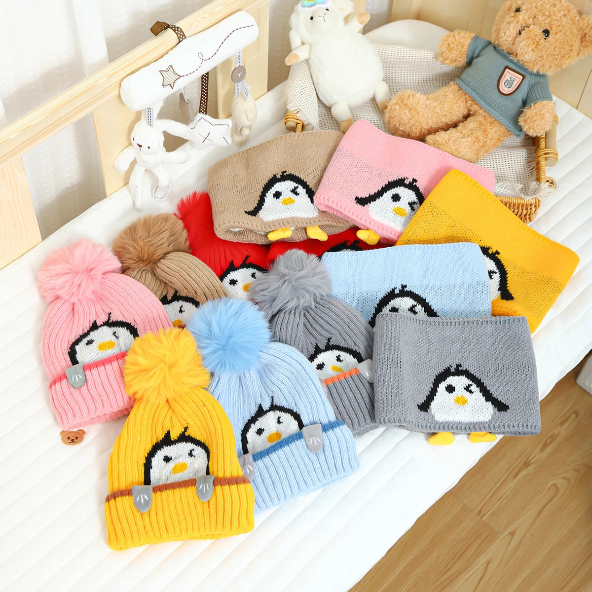 A set of adorable penguin knit hats and scarves in various colors like pink yellow blue and gray displayed on a white surface