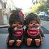 A pair of dark gray plush cartoon characters sitting side by side.