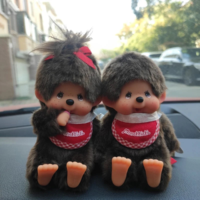 A pair of dark gray plush cartoon characters sitting side by side.