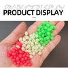 A hand holds a collection of luminous fishing beads in various colors including green, white, and pink.