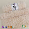 A roll of pink snow fox chunky faux fur yarn is displayed on a fluffy beige background.