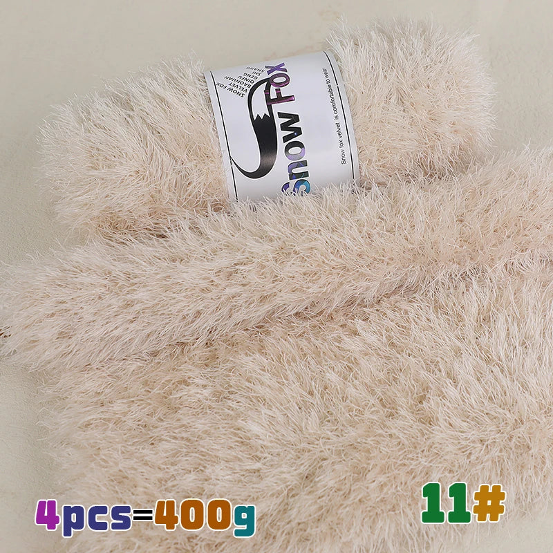 A roll of pink snow fox chunky faux fur yarn is displayed on a fluffy beige background.