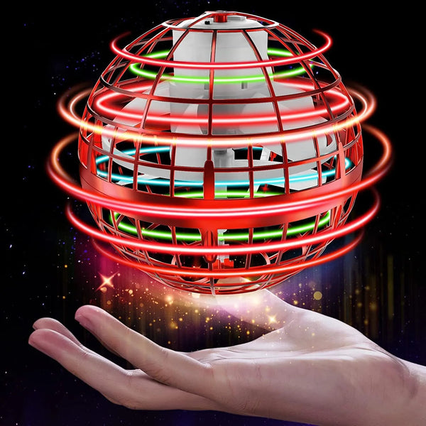 A hand holds a spinning magic flying ball toy with red and green LED lights creating glowing rings.