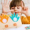 A young child is demonstrating finger counting with a wooden toy, showing five fingers on one hand and five on another.