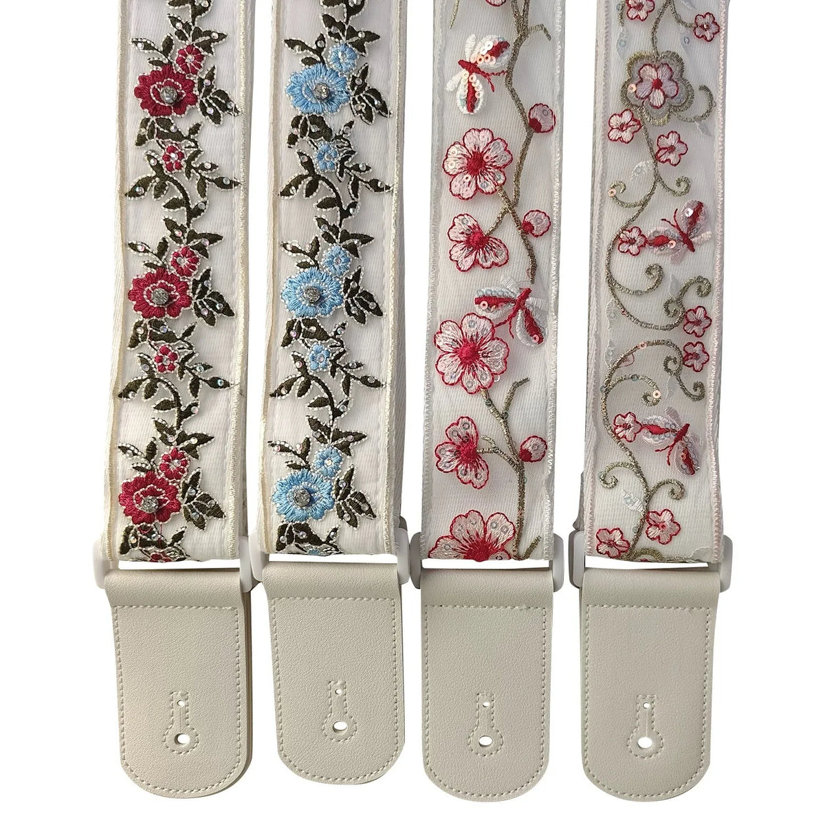 A set of three adjustable woven guitar straps featuring floral embroidery and leather accents.