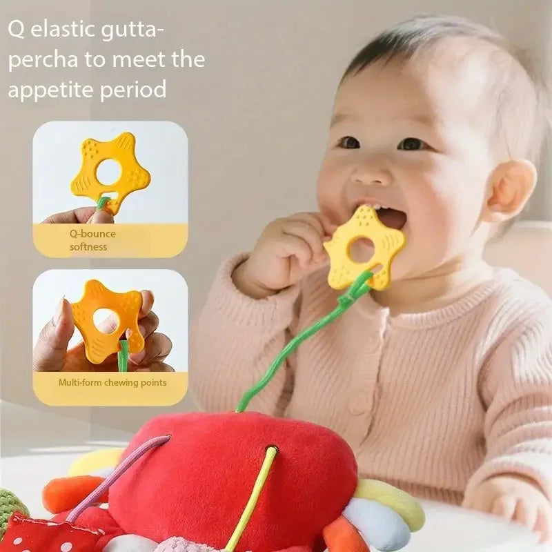 A baby is using a yellow Q elastic gutta-percha toy with multi-form chewing points on a green strap.
