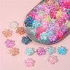 A collection of colorful acrylic flower beads in various shades of pink, blue, and yellow are displayed on a silver tray.