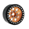 A close-up view of a black metal beadlock wheel with an orange finish and multiple bolt holes.